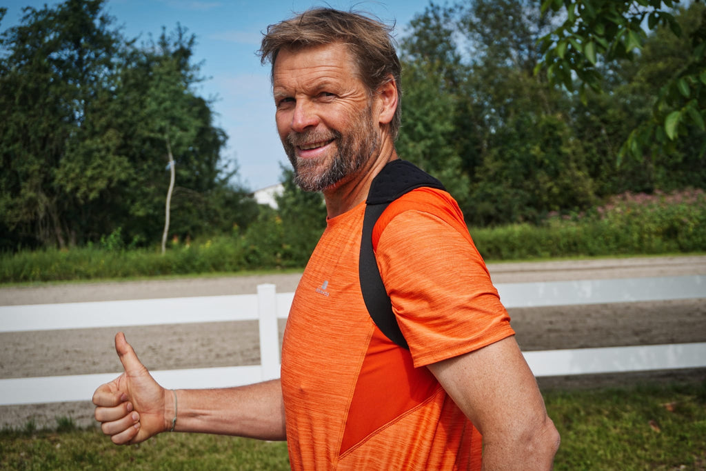 Lächelnder Mann im Sport-T-Shirt trägt das MT-Band und zeigt den Daumen nach oben